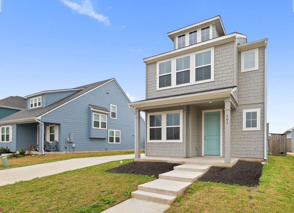 Two-story gray home with a teal front door and concrete walkway, beside a blue neighboring house.
