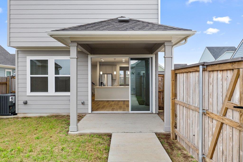 Rear of a gray two-story home with a covered patio and sliding glass door.