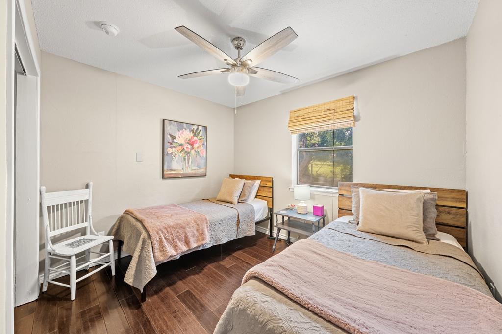 Bedroom with two twin beds, a white rocking chair, and a ceiling fan.