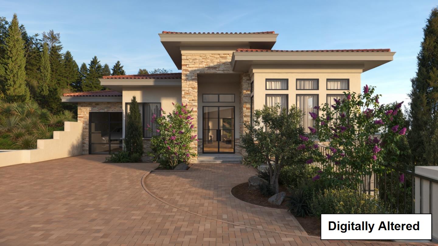 Modern home with stone accents and a brick-paved driveway framed by flowering shrubs.
