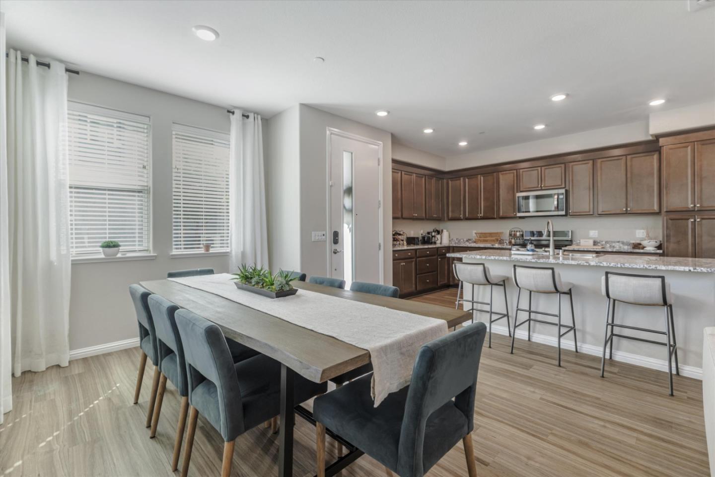 Open-plan dining area and kitchen with a long table and a large island with bar seating.