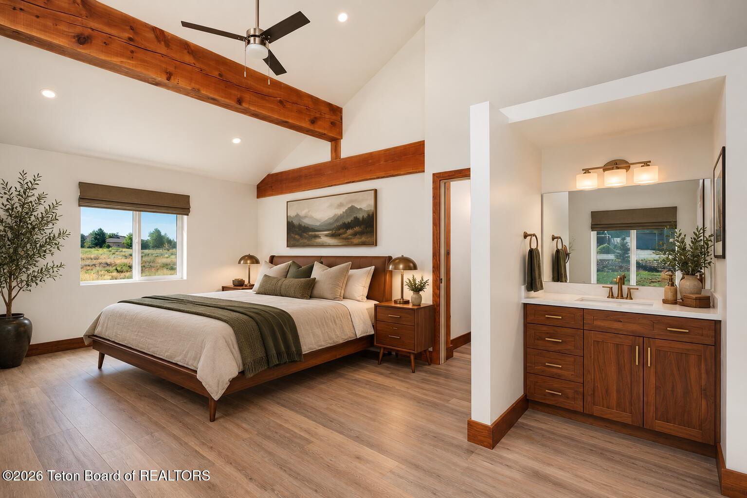Bedroom with exposed wood beams, a king-size bed, and an ensuite bathroom vanity.
