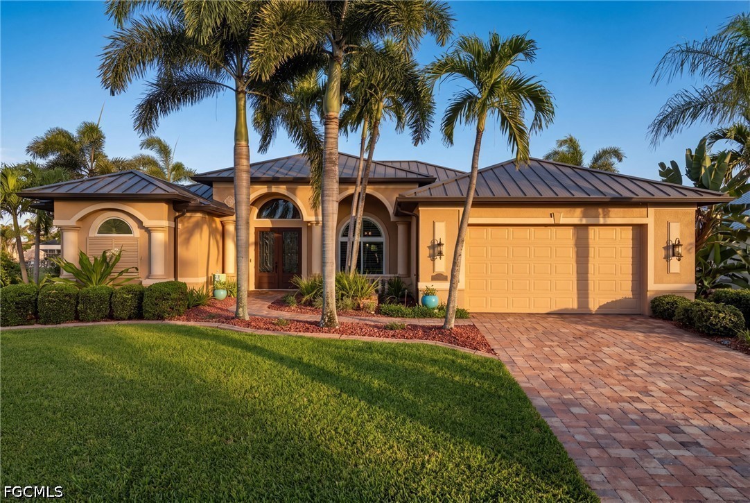 Single-story Florida home with a metal roof, palm trees, and a paver driveway.