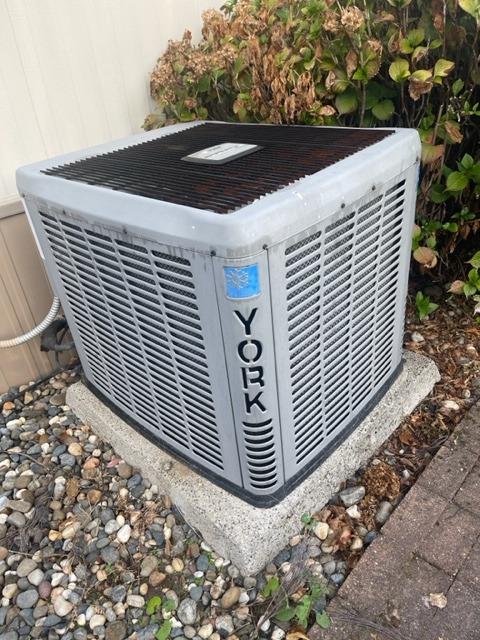 York outdoor air-conditioning unit on a concrete pad beside the house.