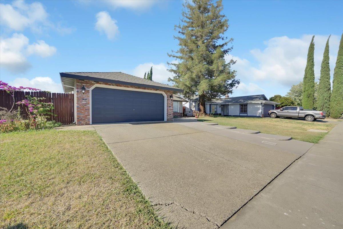 Single-story home with a brick-front two-car garage and wide concrete driveway.
