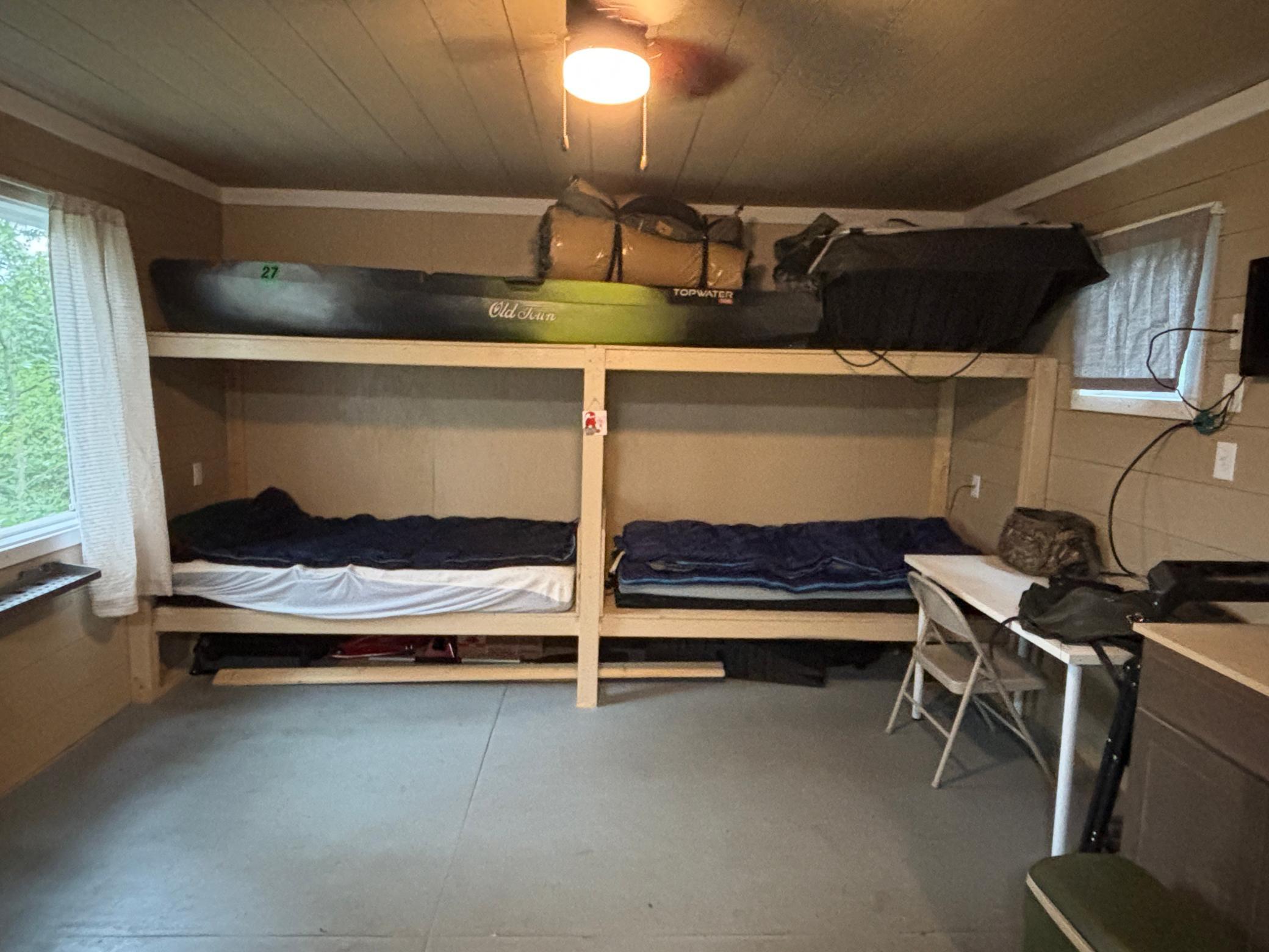 Bunk room with two built-in beds and a kayak stored overhead.