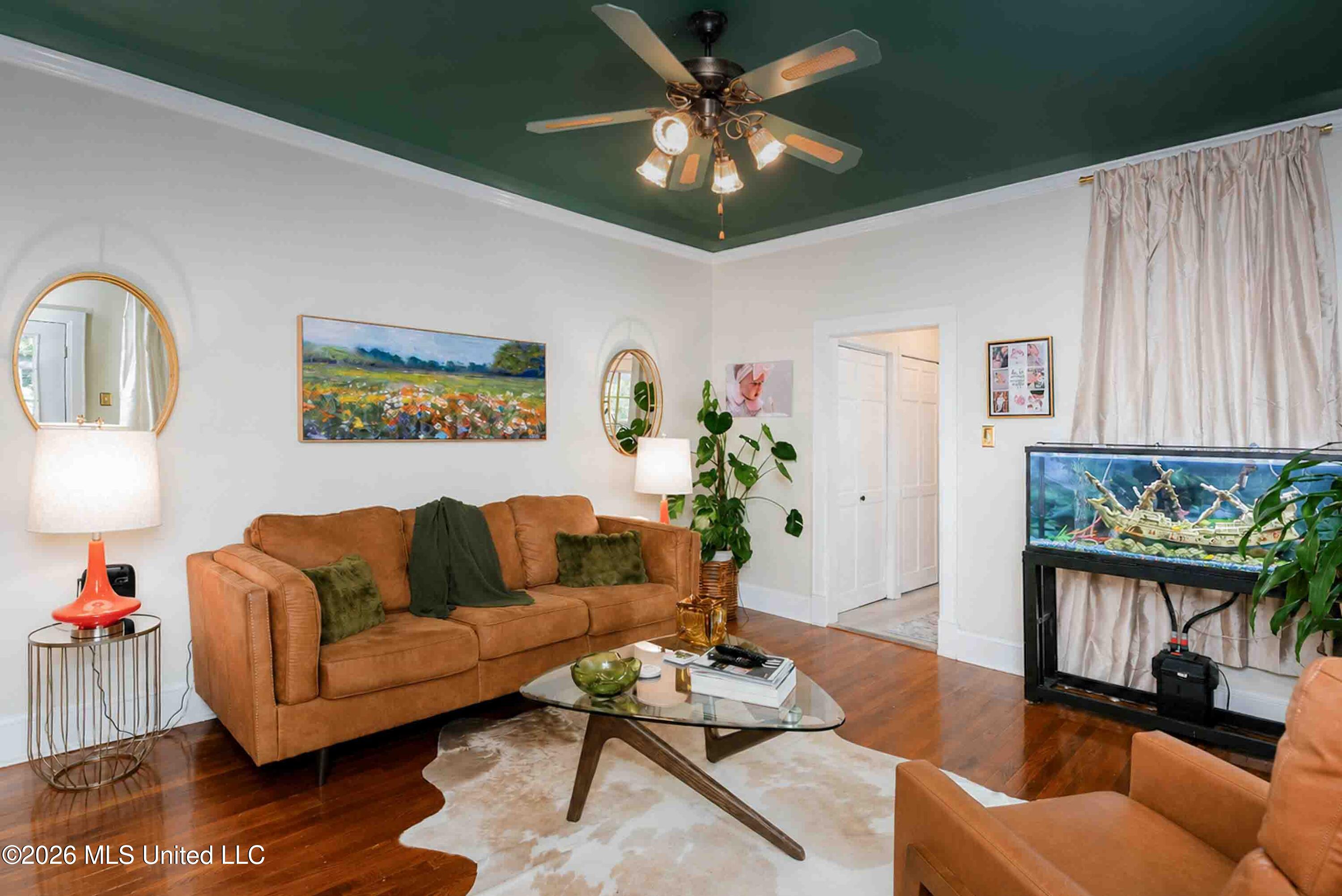 Living room with a cognac leather sofa, dark green ceiling, and large aquarium.