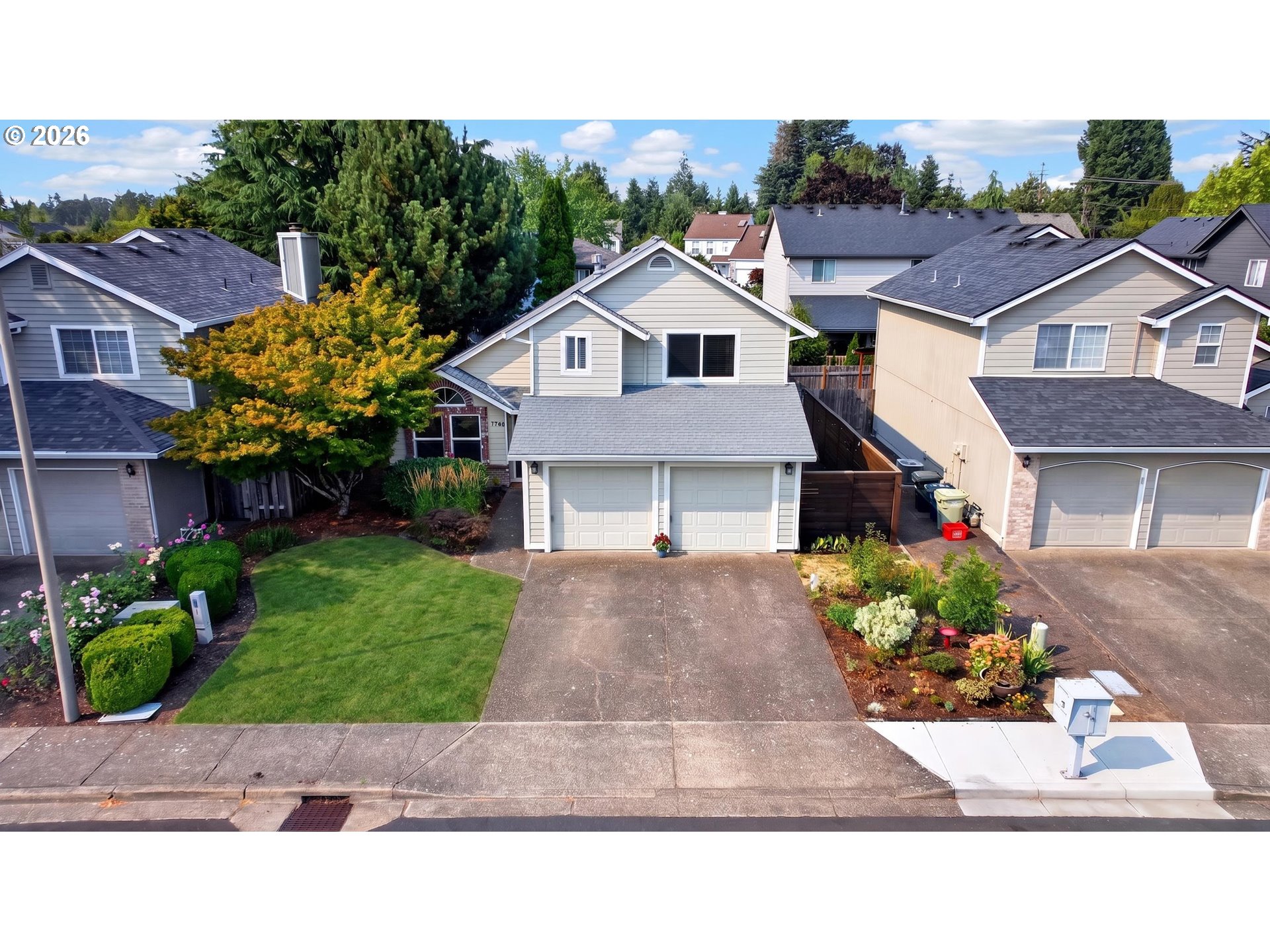 Aerial view of a two-story house with a double garage and landscaped front yard.