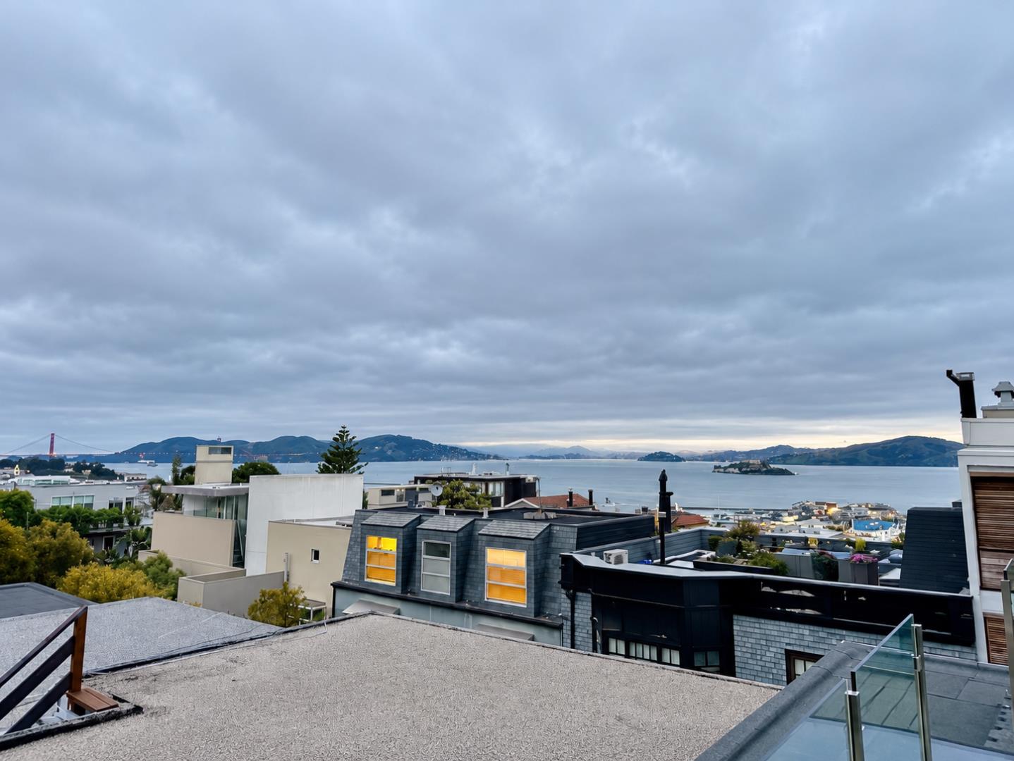 Bay and island views from a rooftop terrace above San Francisco homes.