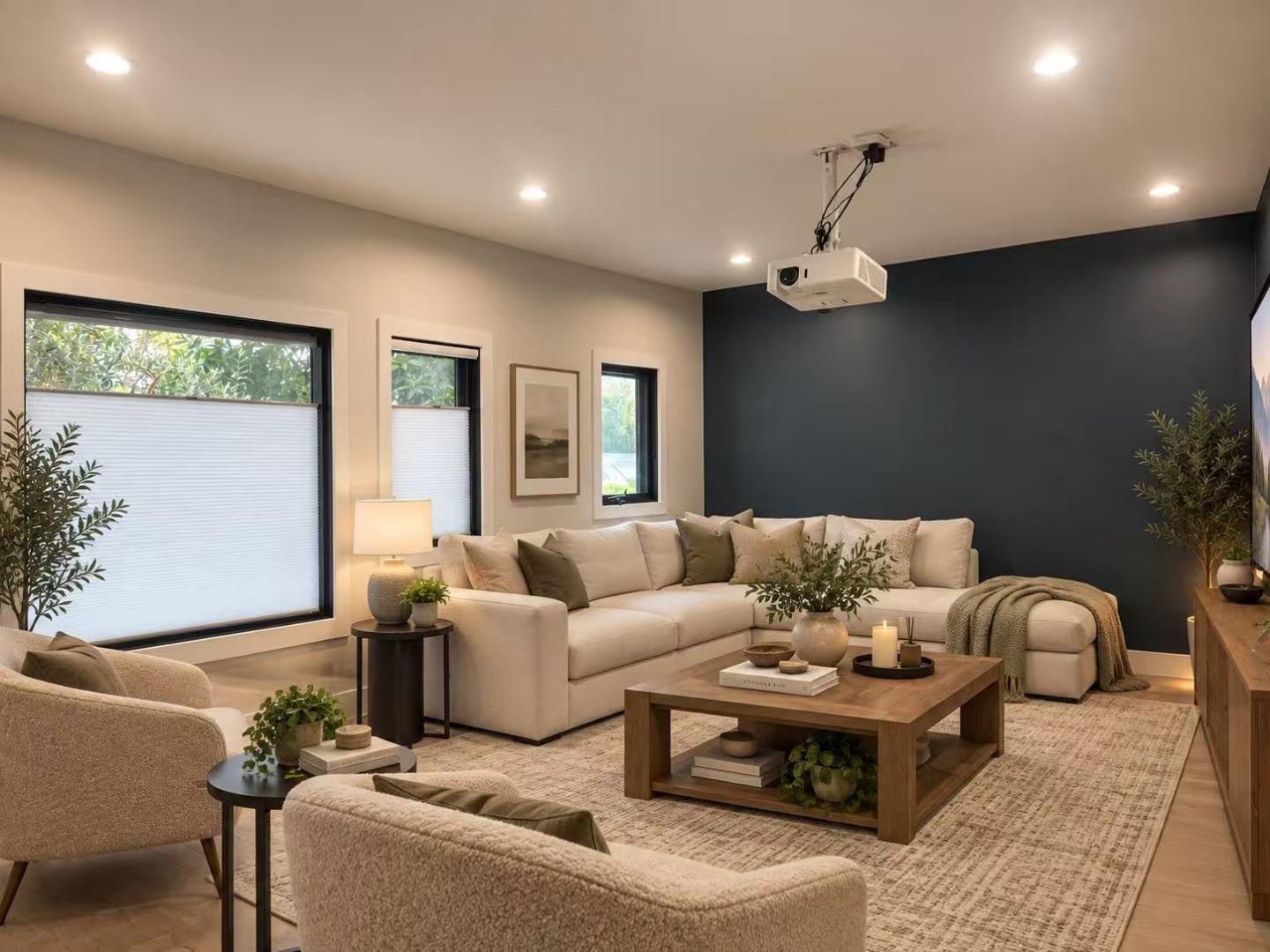 Living room with a cream sectional, dark accent wall, and ceiling-mounted projector.