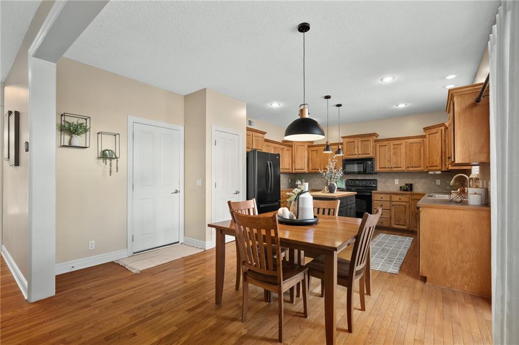 Kitchen and dining area with wood cabinetry, stainless steel appliances, and a wooden table.
