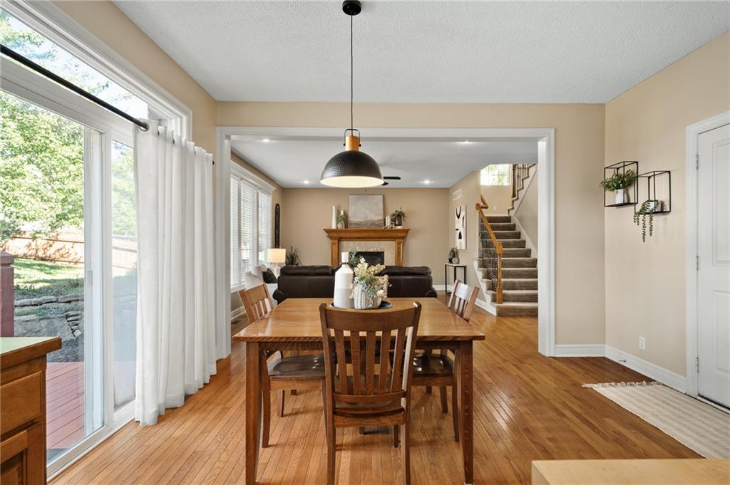 Dining room with a wooden table, hardwood floors, and sliding glass doors opening to the yard.