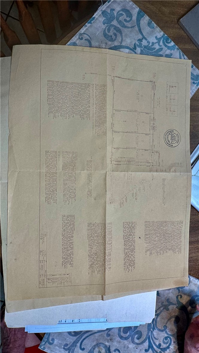 Folded land survey plat showing parcel boundaries, measurements, and legal descriptions.