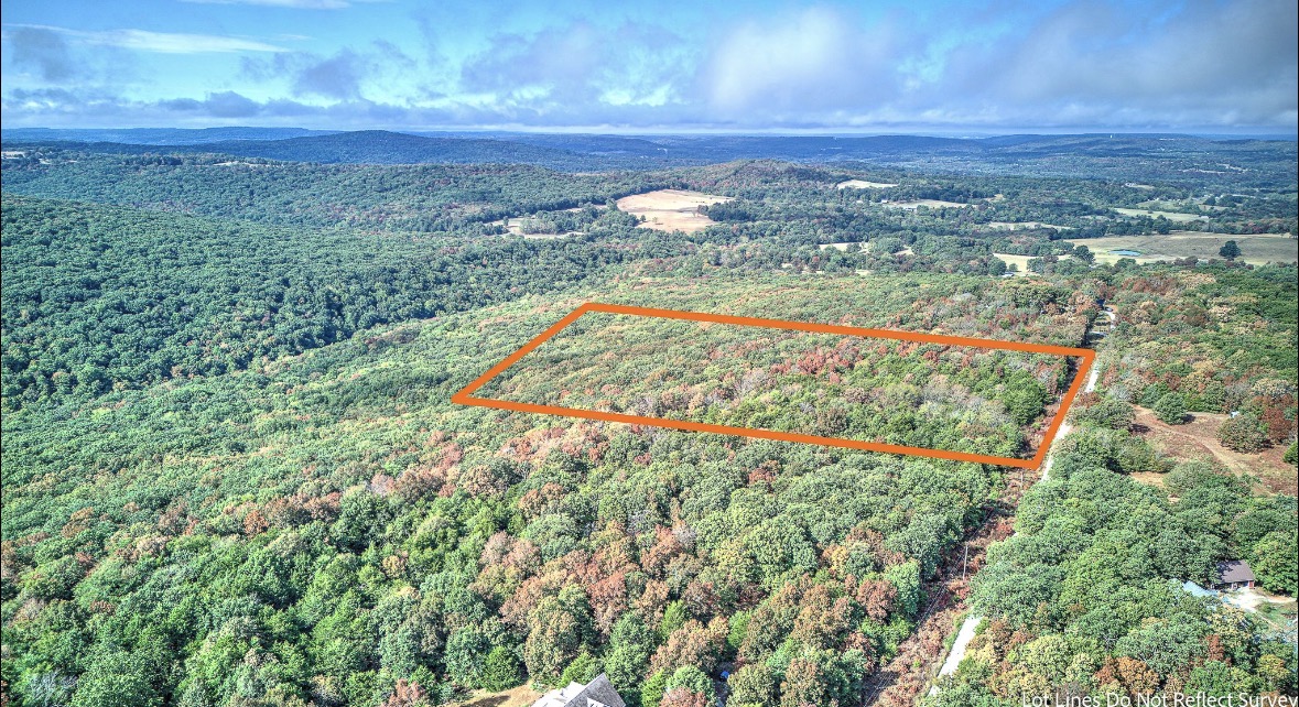 Aerial view of a wooded parcel outlined in orange, surrounded by rolling forest.