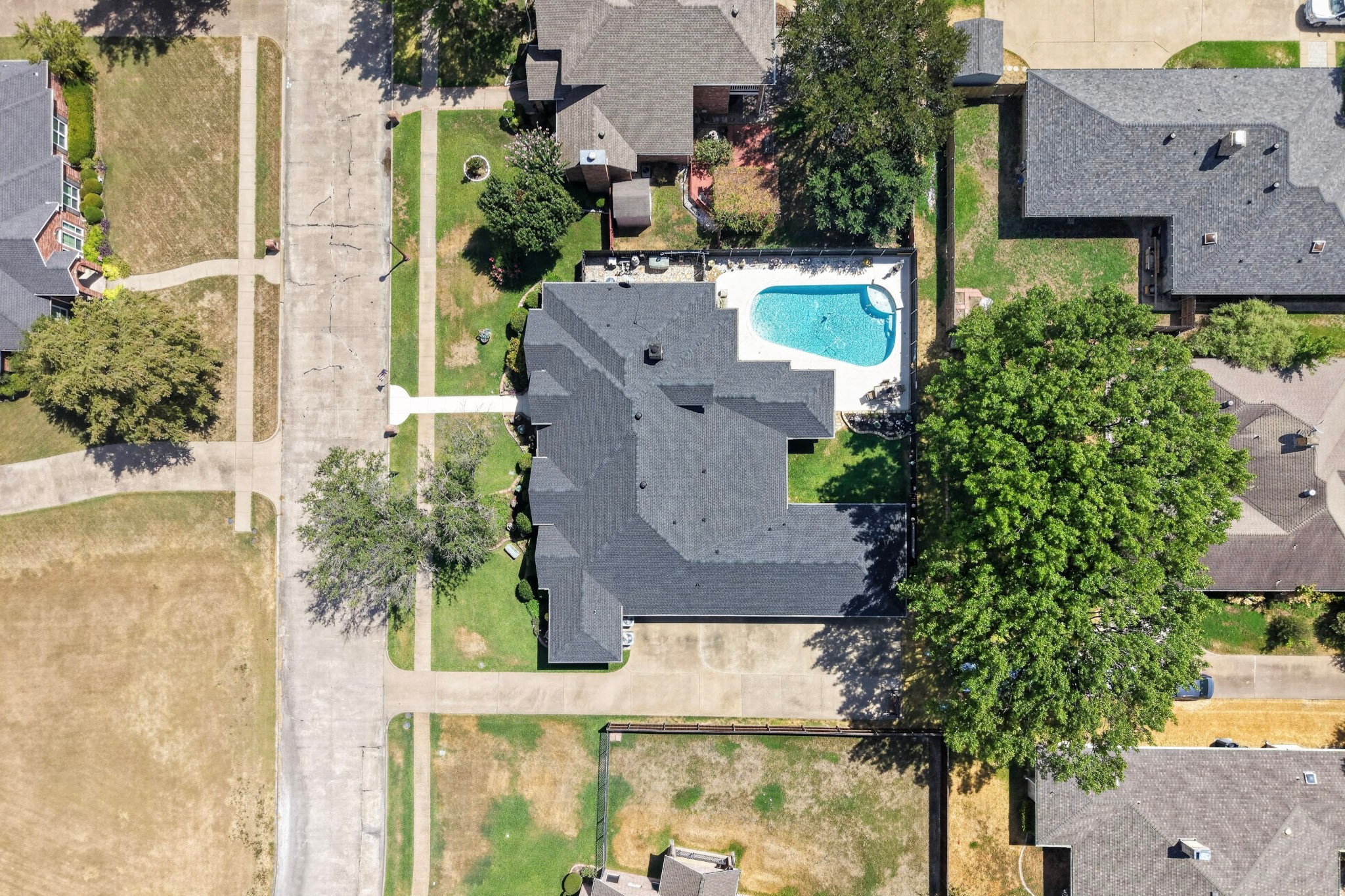 Aerial view of a home with a fenced yard and swimming pool.