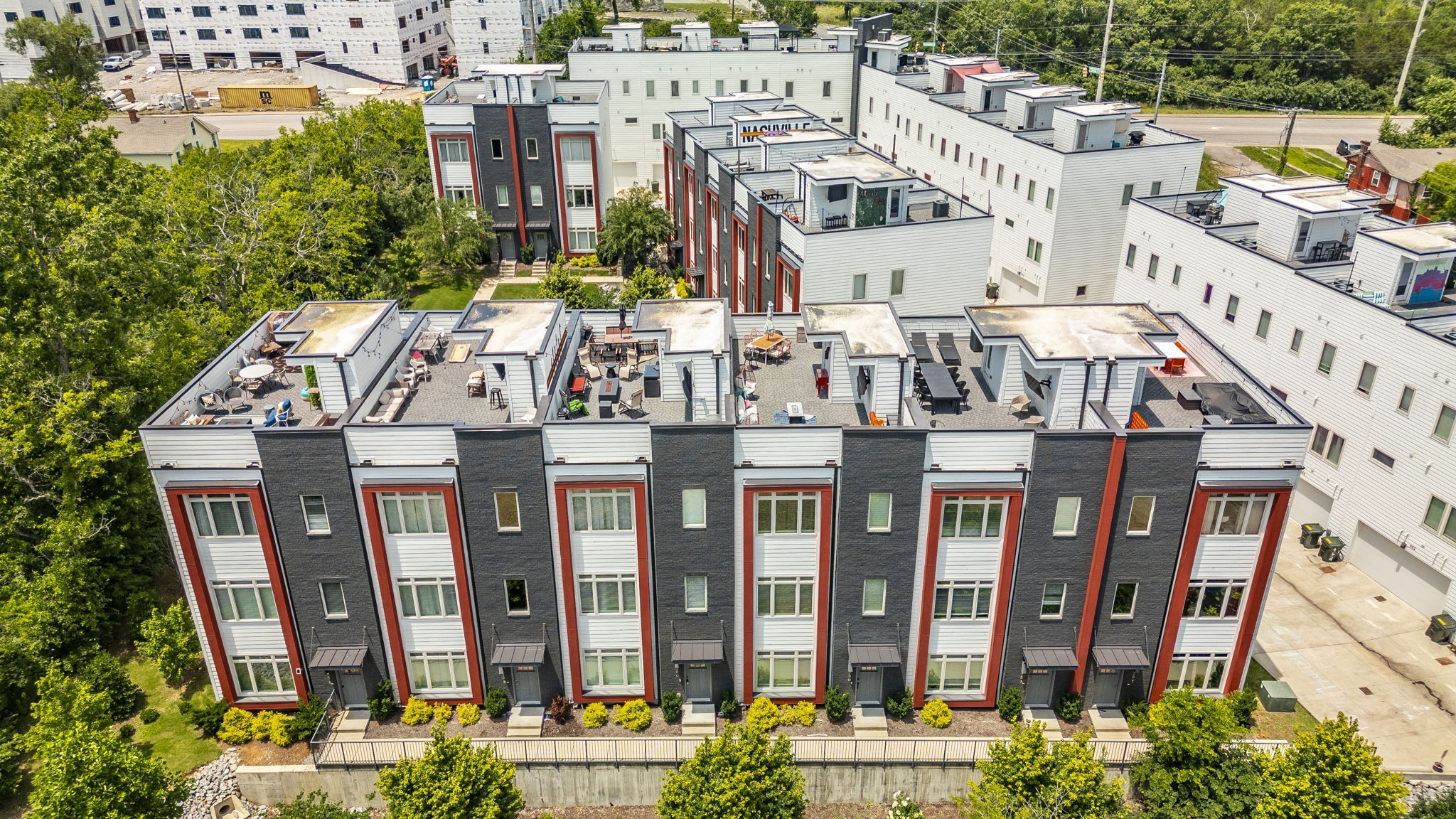 Modern townhomes with furnished rooftop terraces, viewed from above.