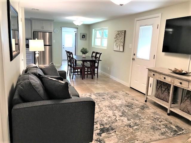 Open-plan living and dining area with a gray sofa and dark wood dining set.