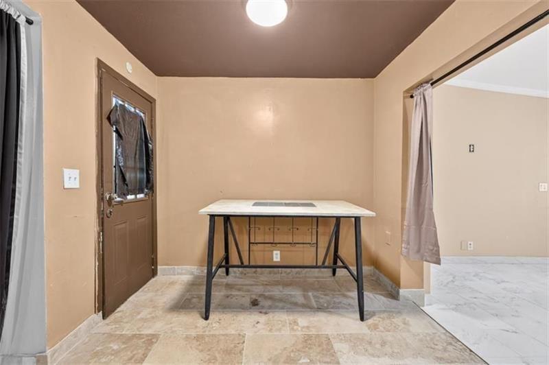 Room with tan walls, tiled floors, and a white-topped table with a dark inset surface.