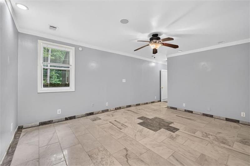 Empty room with patterned tile flooring, a ceiling fan, and a window with blinds.