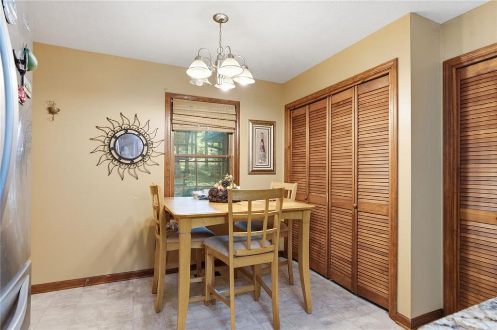 Dining area with a wooden table, window, and louvered cabinets.