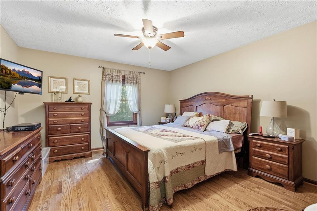 Furnished bedroom with a large wooden bed, matching dressers, and hardwood floors.