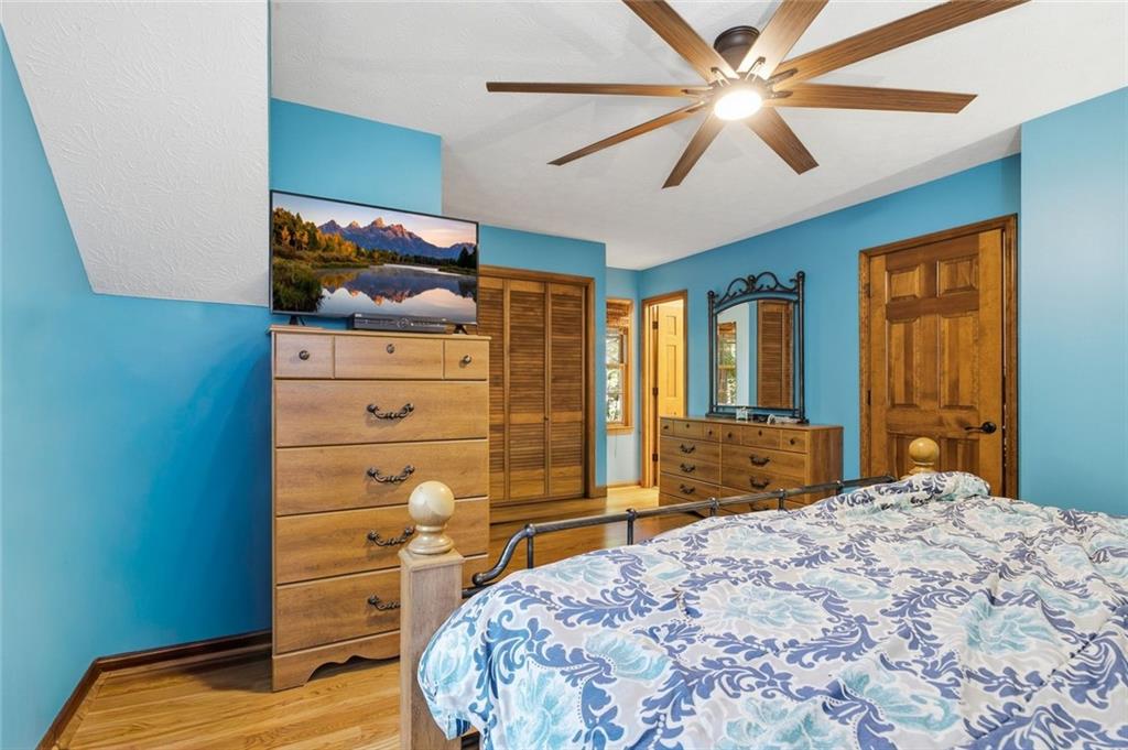 Bedroom with turquoise walls, wooden dressers, and blue-and-white patterned bedding.