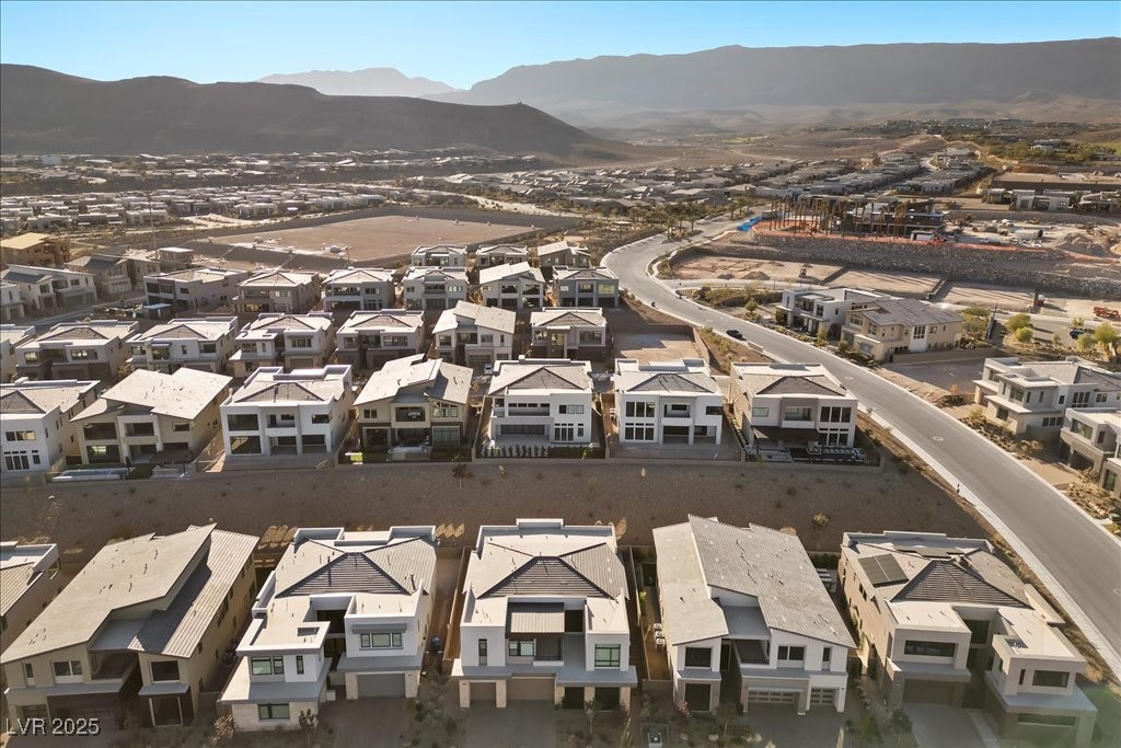 Aerial view of modern homes in a Las Vegas neighborhood, with mountains in the distance.