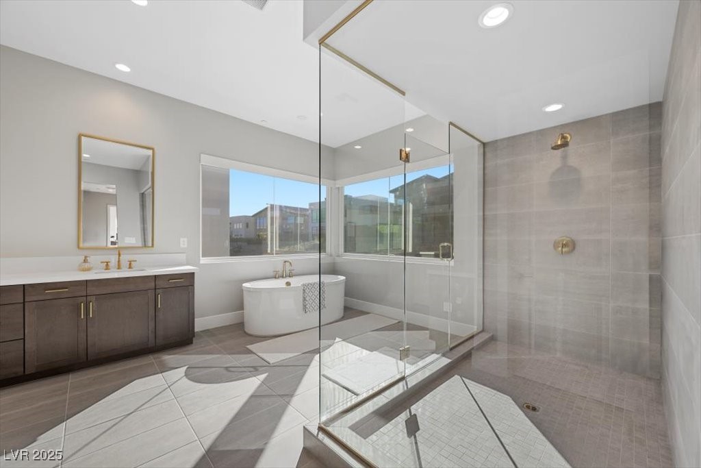 Modern bathroom with a freestanding tub, glass-enclosed shower, and dark wood vanity.