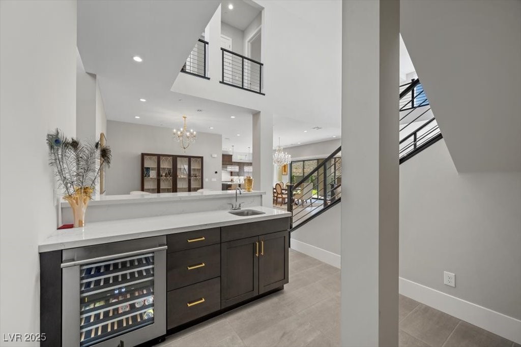 Wet bar with a built-in wine refrigerator overlooks a bright, open two-story interior.