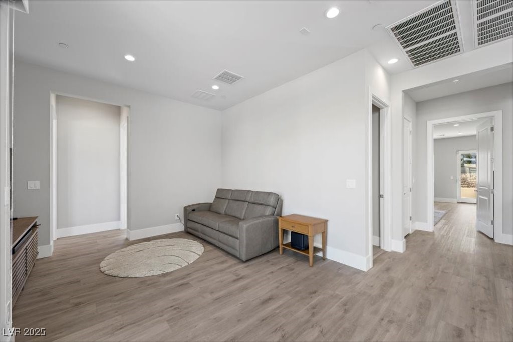 Living room with a gray sofa, round cream rug, and hallway doorway.