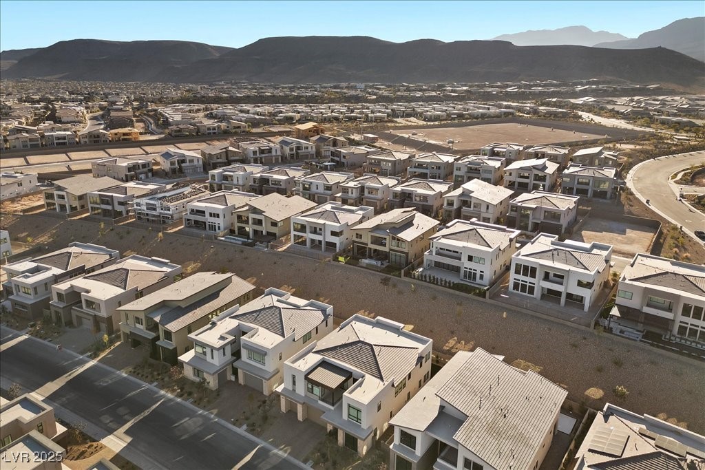 Aerial view of modern homes in a Las Vegas neighborhood with mountains beyond.