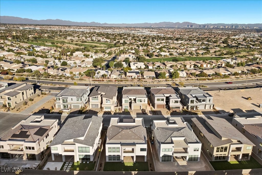 Aerial view of modern Las Vegas homes, with the city skyline and mountains in the distance.