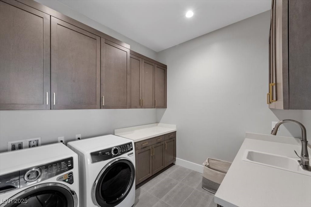 Laundry room with dark wood cabinets, front-loading washer and dryer, and a utility sink.