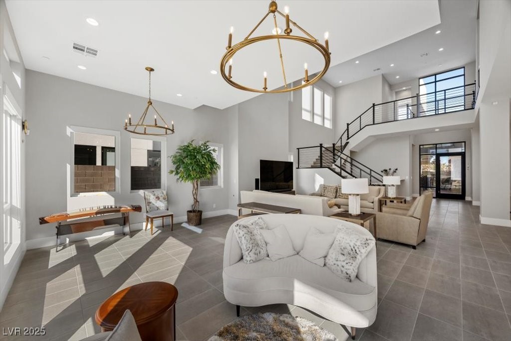 Two-story living room with a white sofa, large windows, and an open staircase.