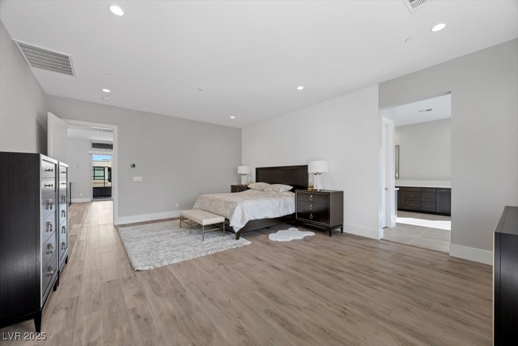 Furnished bedroom with a dark wood bed, matching dressers, and an adjoining bathroom.