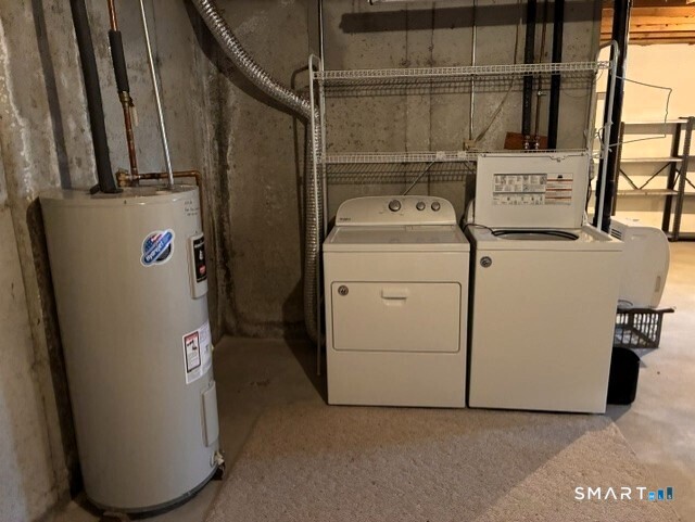 Basement laundry area with a washer and dryer, wire shelving, and a water heater.