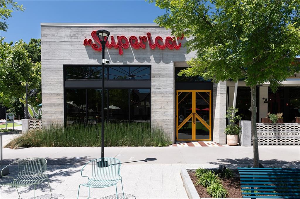 Superica restaurant storefront with a red sign, yellow-framed entrance, and sidewalk seating.