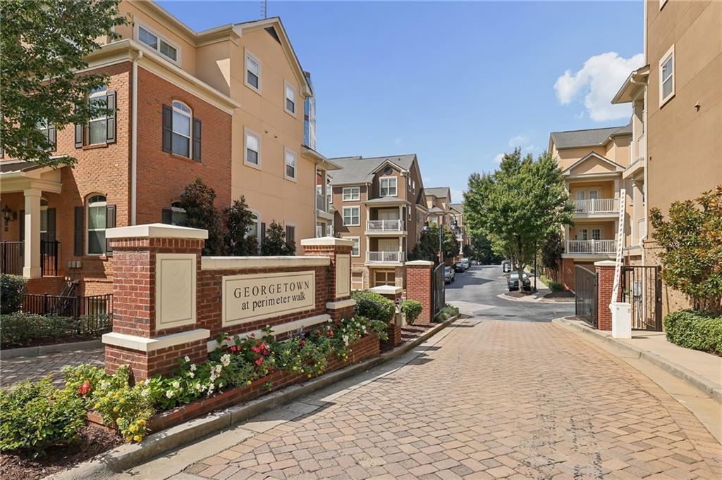 Georgetown at Perimeter Walk entrance with brick sign, landscaped beds, and townhouses.