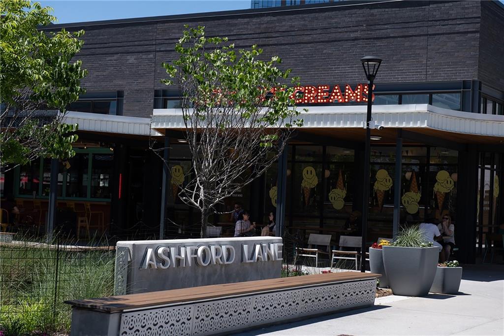 Ashford Lane shopping center with storefront windows, outdoor seating, and a large sign in front.