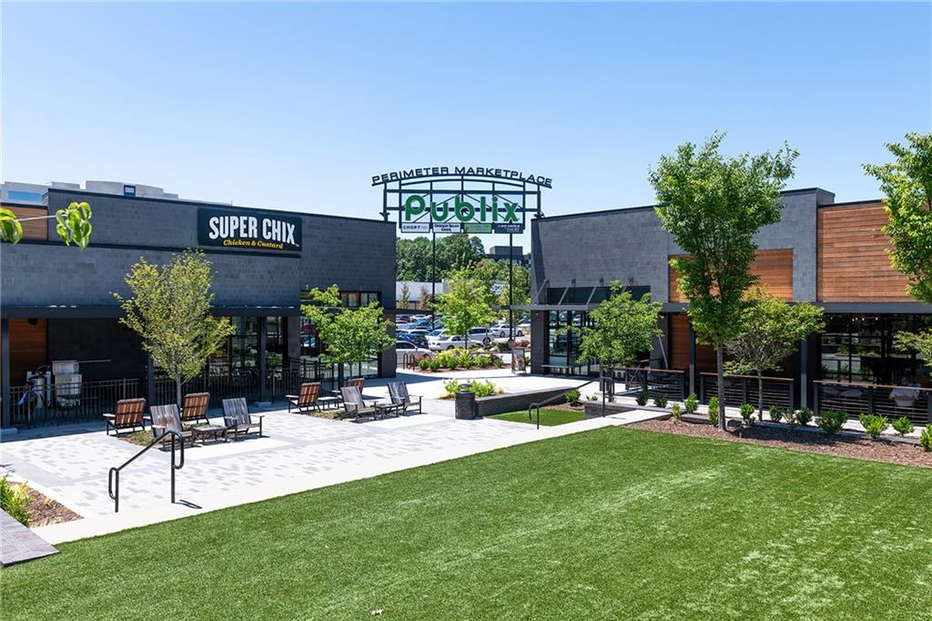 Perimeter Marketplace courtyard with lawn, outdoor seating, and retail storefronts.