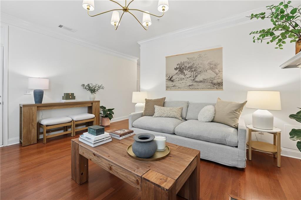 Living room with a gray sofa, wood coffee table, and warm hardwood floors.