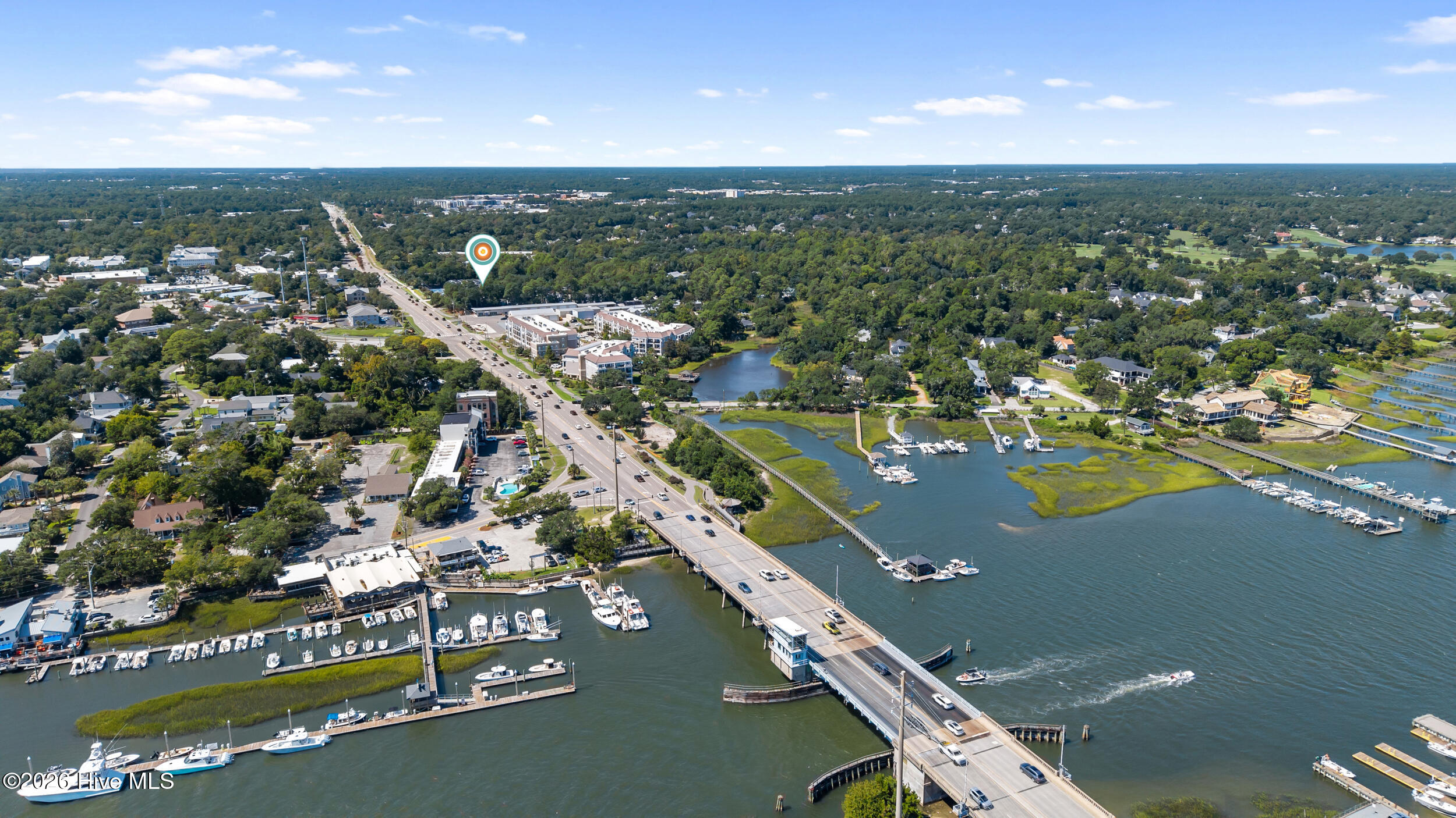 Aerial view of the property area, with a bridge crossing the water beside marinas and wooded neighborhoods.