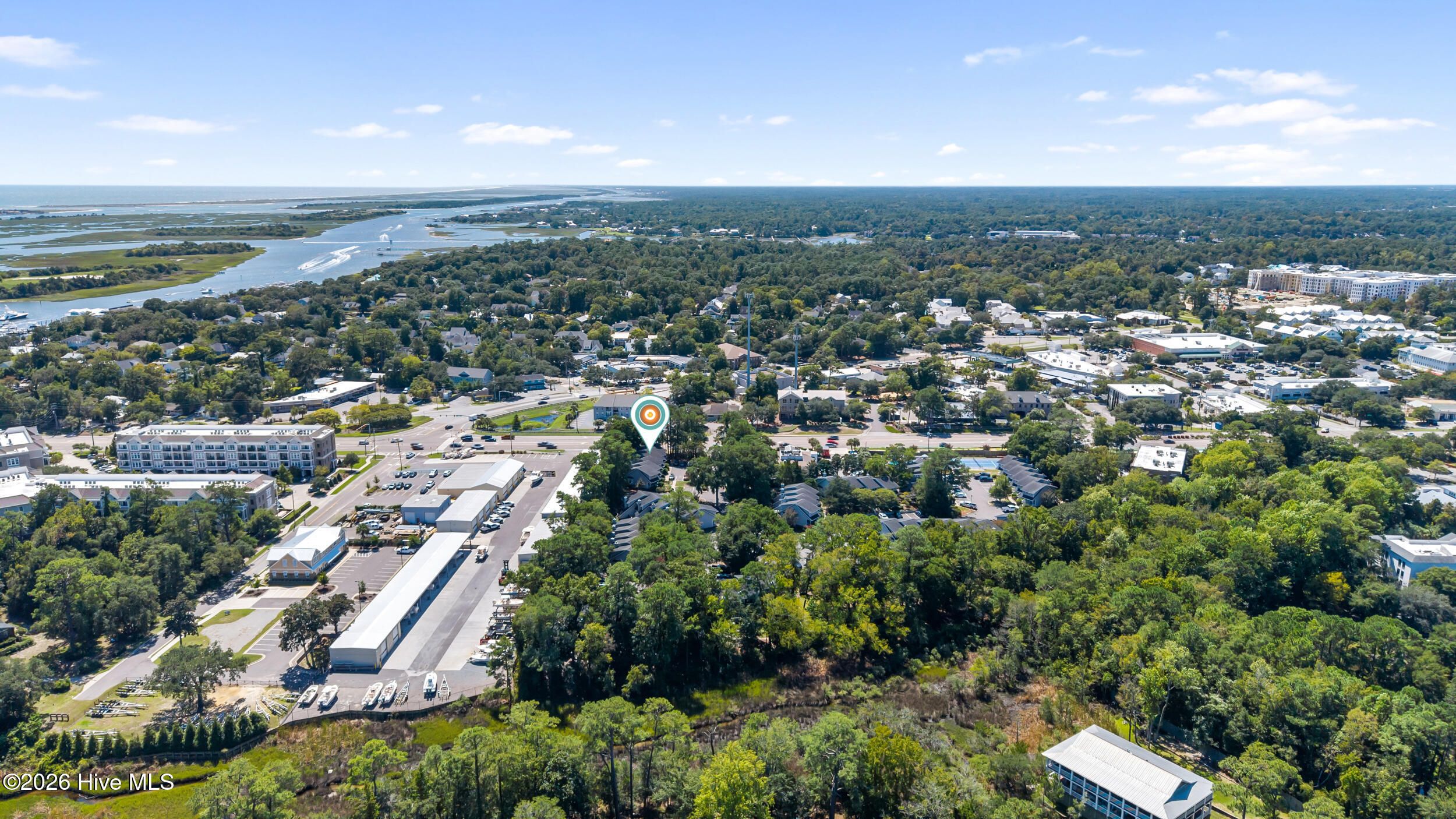 Aerial view of the property marked by a pin, with nearby waterways, marina, and ocean beyond.