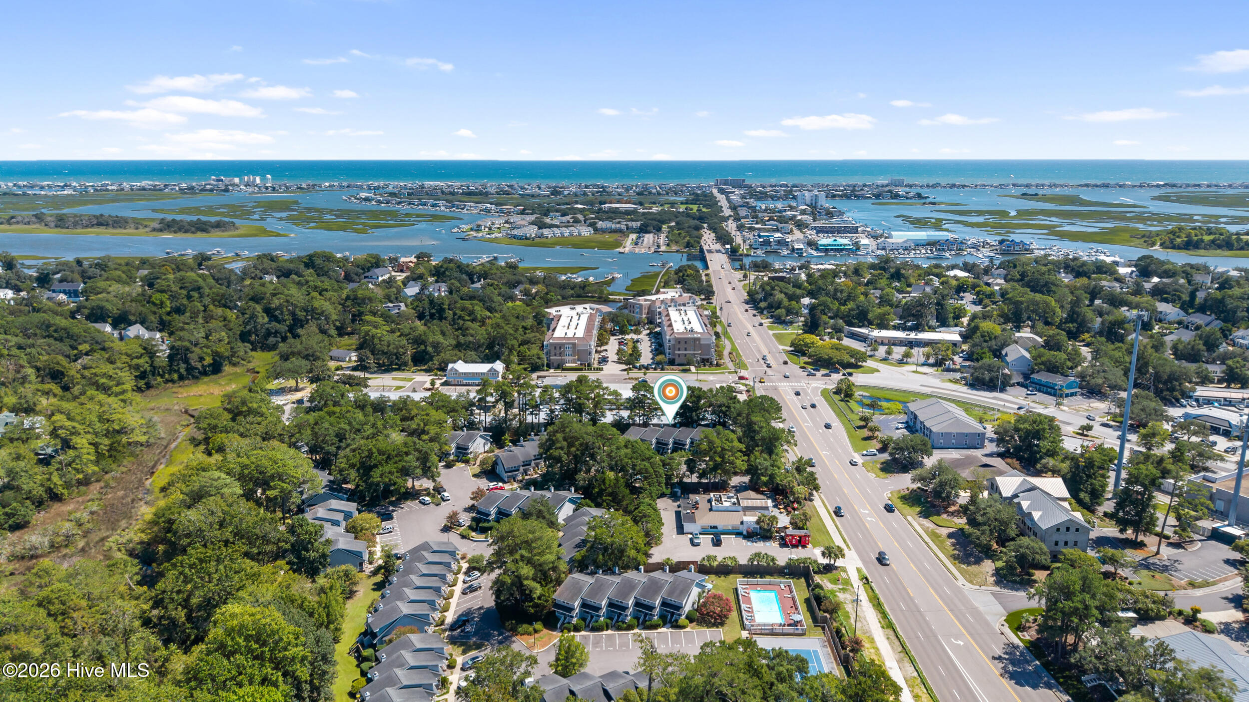 Aerial view of a residential community near coastal marshes, waterways, and the ocean.