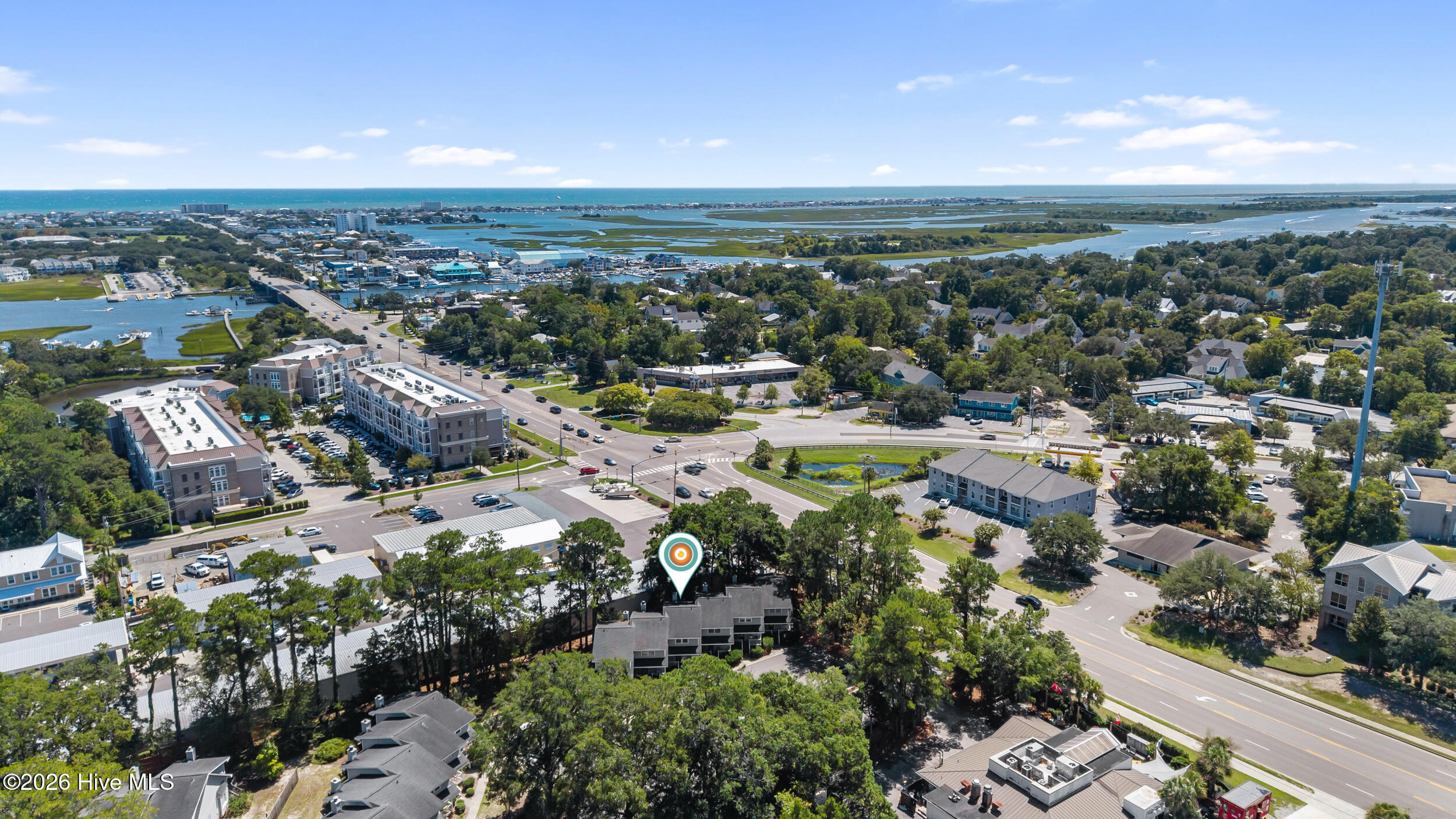 Aerial view of the property area, with a map pin, coastal marshes, waterways, and ocean beyond.