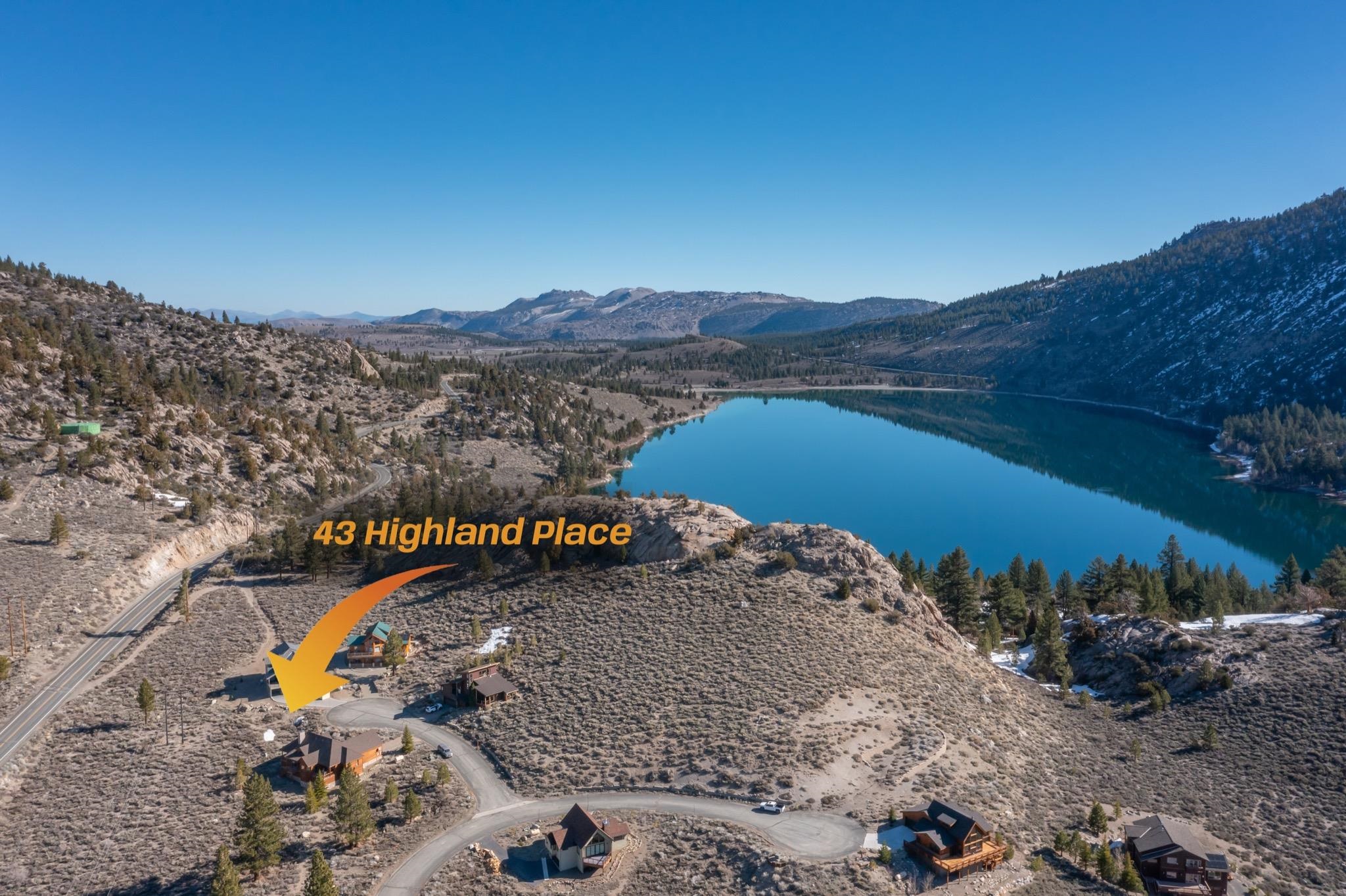 Aerial view of 43 Highland Place, marked by an orange arrow beside a mountain lake.