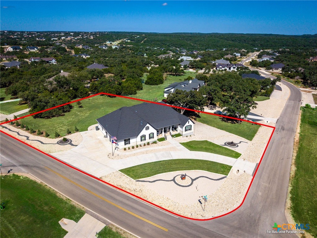 Aerial view of a one-story home on a landscaped corner lot outlined in red.