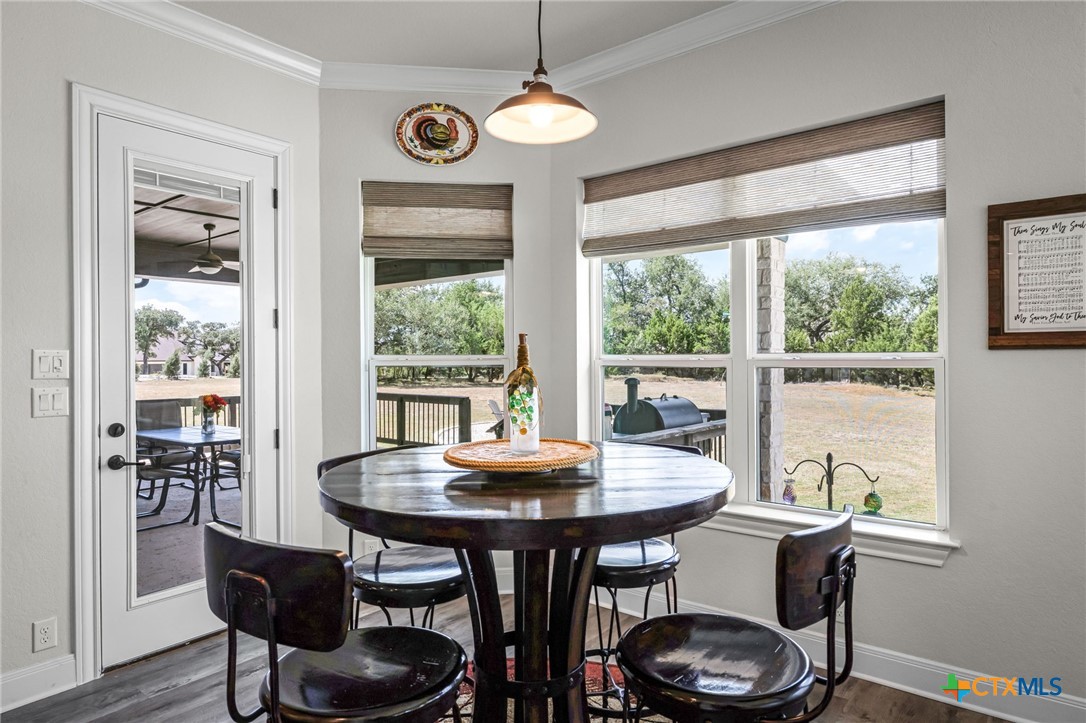 Dining nook with a round wood table, large windows, and a view of the yard.