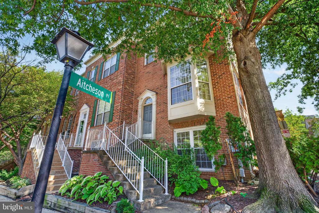 Brick townhouse on Aitcheson Place, framed by a mature tree and white-railed steps.