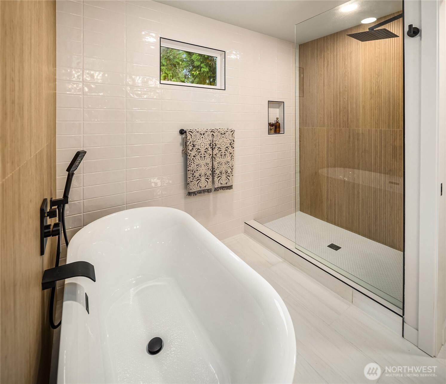 Modern bathroom with a freestanding soaking tub and glass walk-in shower with wood-look tile.